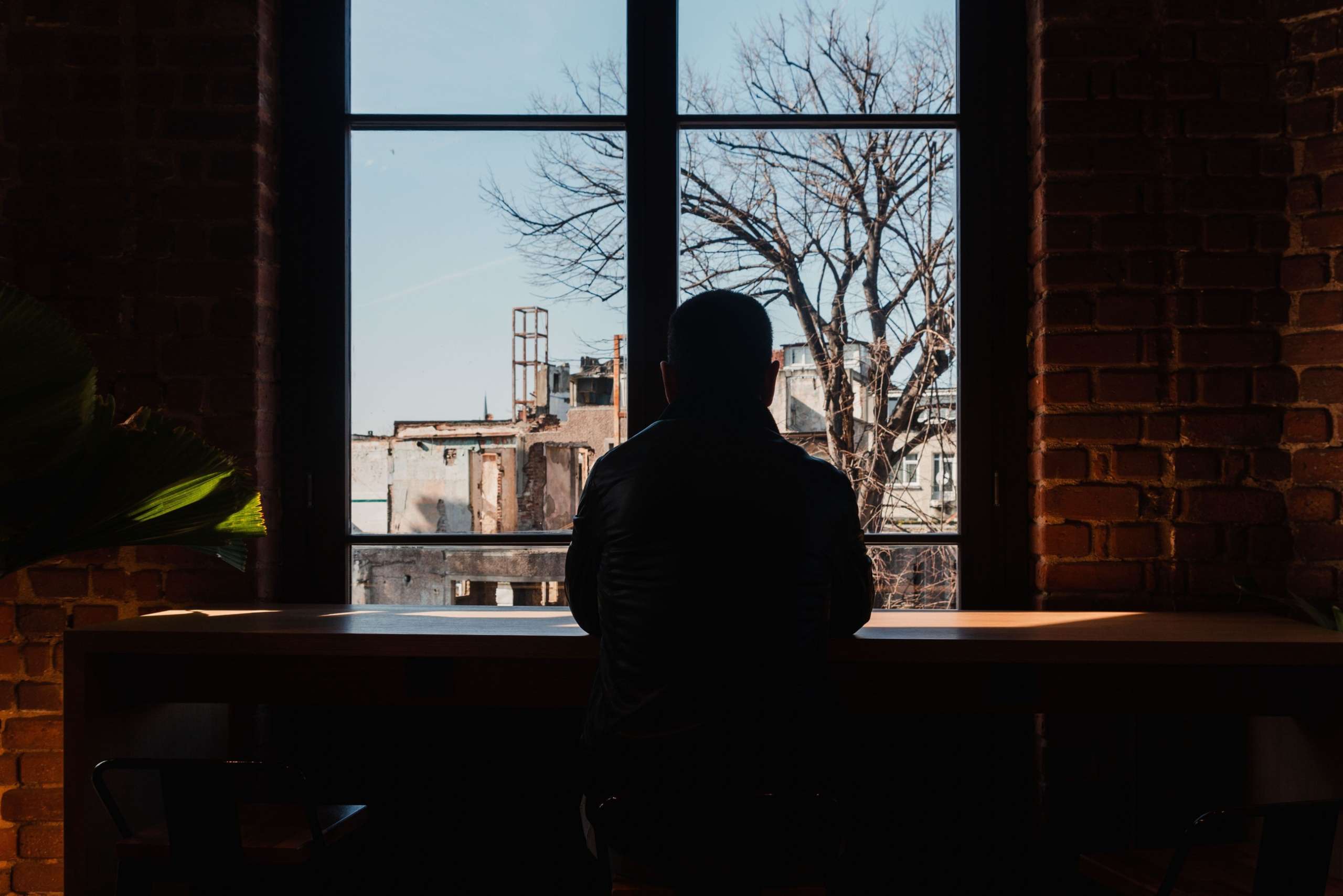 hombre solo mirando por la ventana